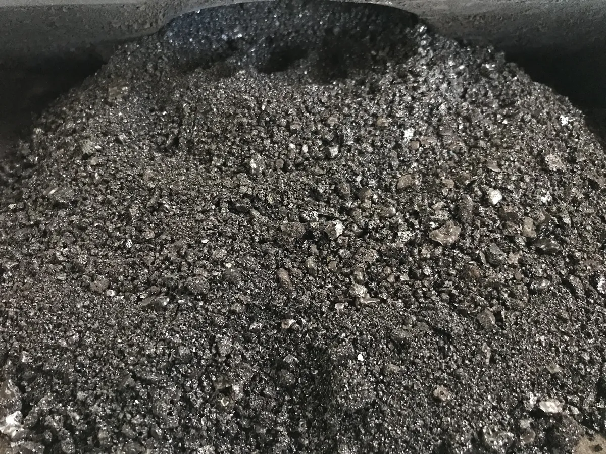 受け皿にたまったタールとススの粒。黒く光るかけらが混じっている
