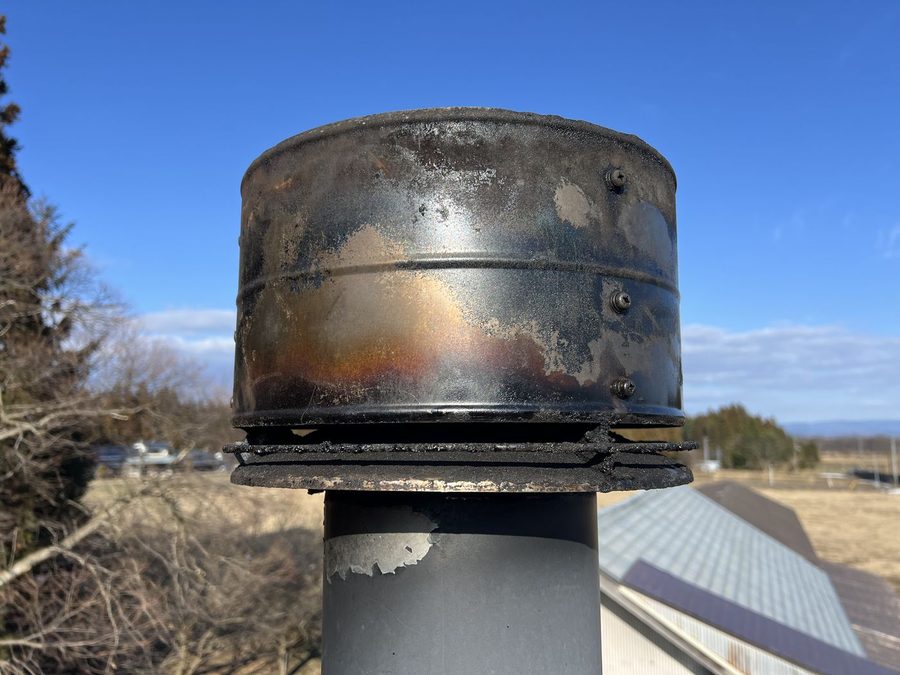 掃除後の同じ煙突トップ。フチのタールの塊は無くなり、地金と焼けた鉄の色が見えている
