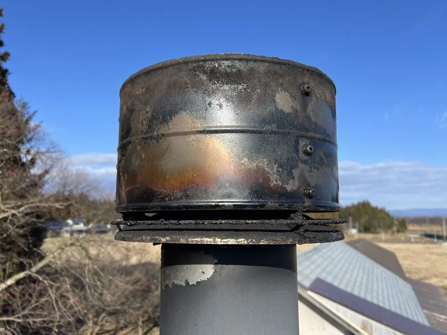 掃除後の同じ煙突トップ。フチのタールの塊は無くなり、地金と焼けた鉄の色が見えている