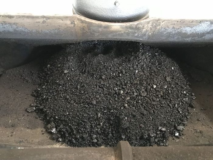 金属の受け皿に山盛りになった、黒くツヤのあるタールとススの粒