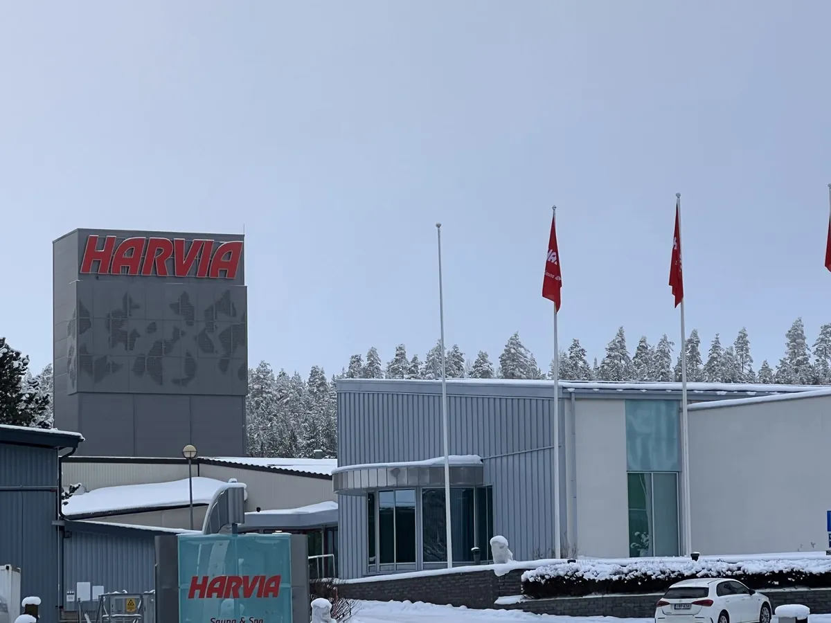 雪の森を背にして建つハルビアの本社。建物の上に赤いHARVIAの看板と社旗が並ぶ
