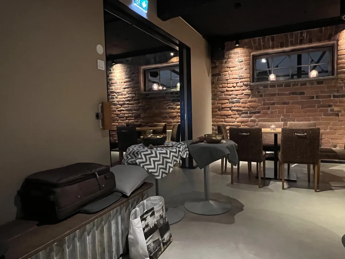 ユヴァスキュラのサウナ施設のラウンジ。古いレンガの壁を残し、木のテーブルと椅子が並ぶ