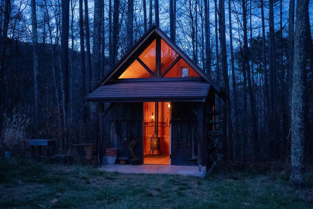 夕暮れの小屋に据えたG1。窓から漏れる炎の灯り