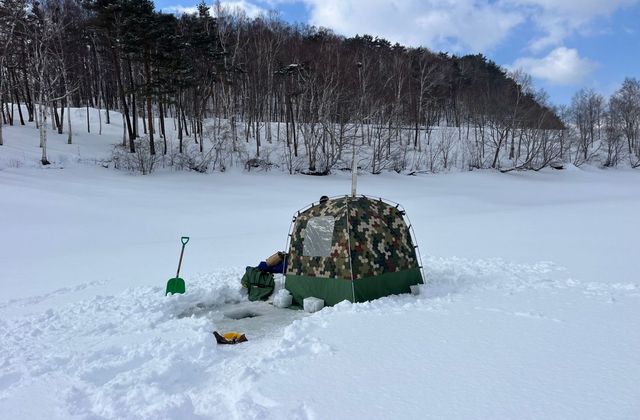 凍った湖の上に張ったテントサウナと氷の水風呂
