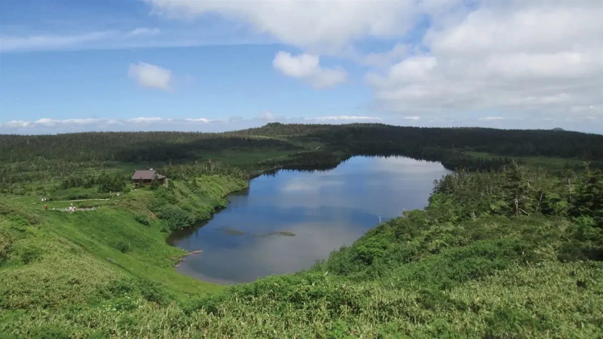 原生林と湿原に囲まれた八幡平最大の火口湖・八幡沼と、ほとりに建つ陵雲荘