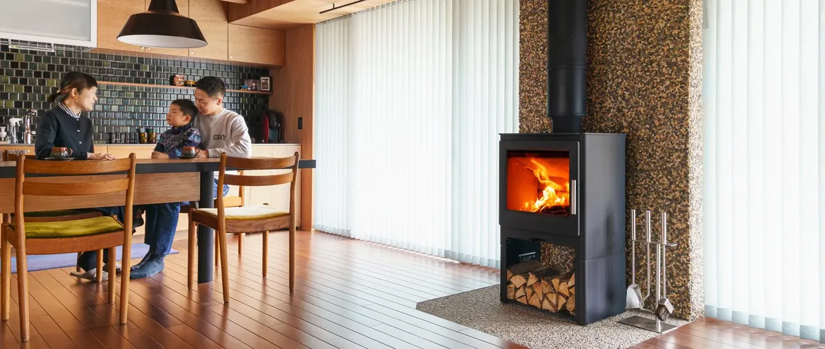 HETA アンビション — 洗い出しの柱ぎわに設置。となりのダイニングでくつろぐ家族(写真:ファイヤーサイド)