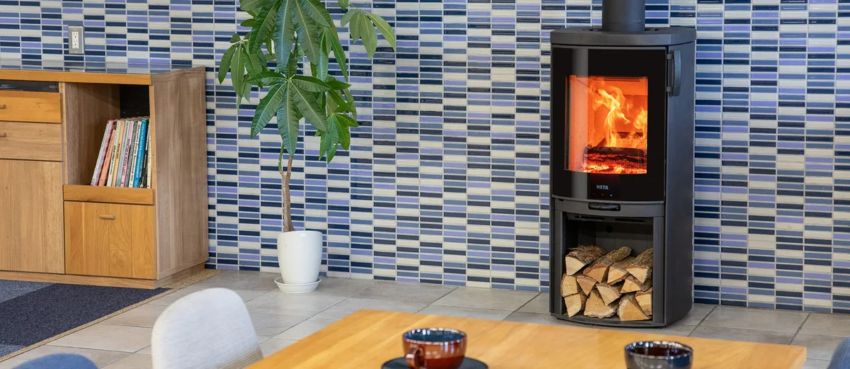 HETA モデルナ — 本棚のそば、薪を入れたスチール仕様(写真:ファイヤーサイド)