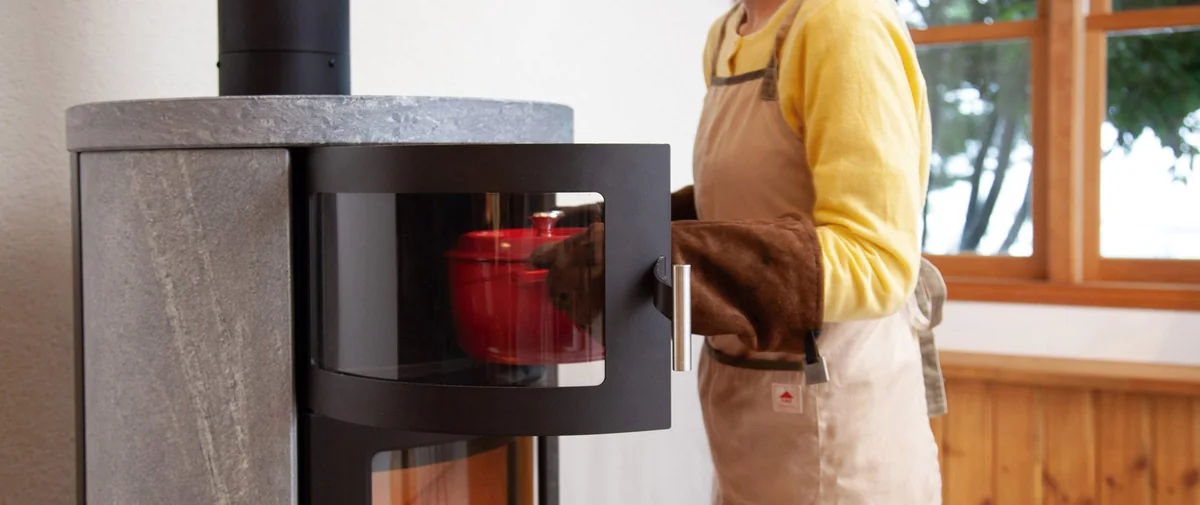 HETA ノルンのオーブンから赤いココットを出すところ(写真:ファイヤーサイド)