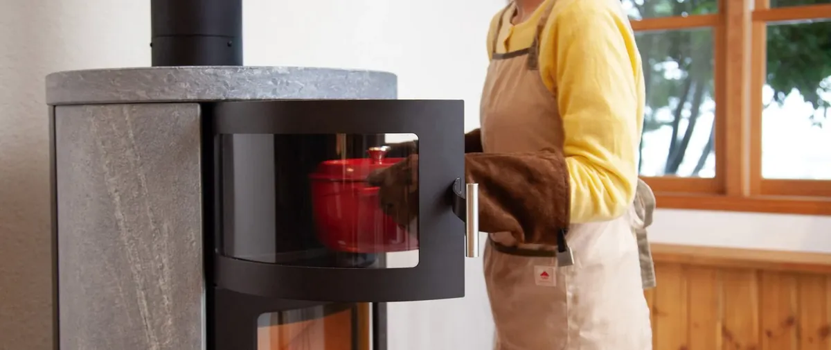 HETA ノルン — オーブンの扉を開けて、赤いココットを取り出すところ(写真:ファイヤーサイド)