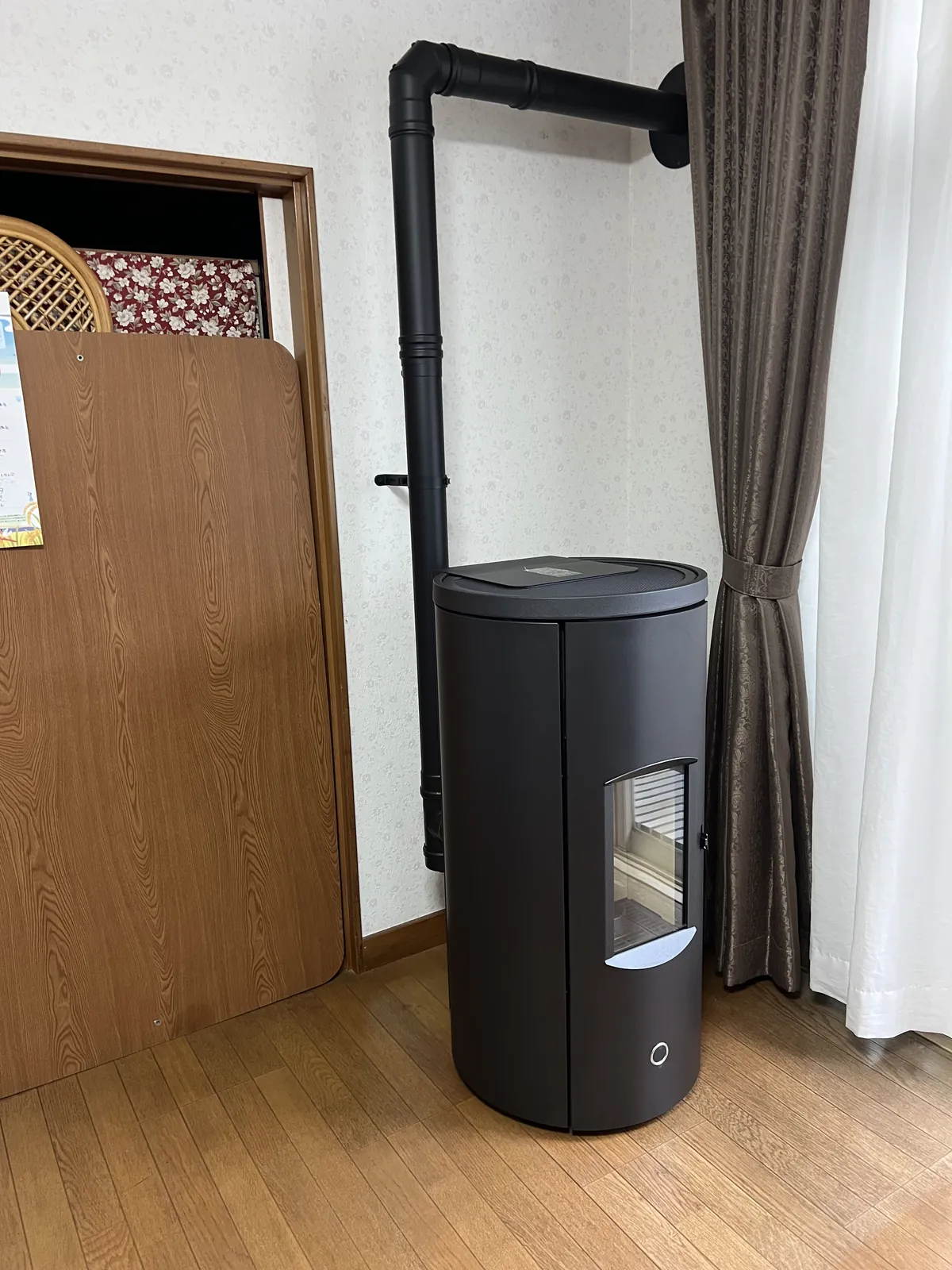 盛岡市の住宅に設置したエディルカミン LIKE 80。丸い胴の黒いボディで、煙突は上へ伸びて壁を抜ける