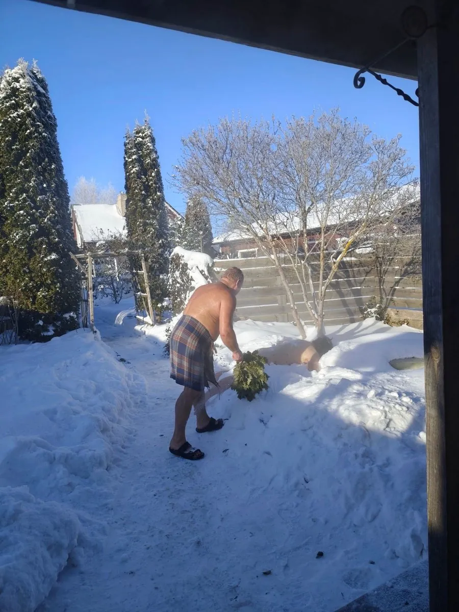 雪に覆われたリトアニアの森。スモークサウナの煙が立ちのぼる