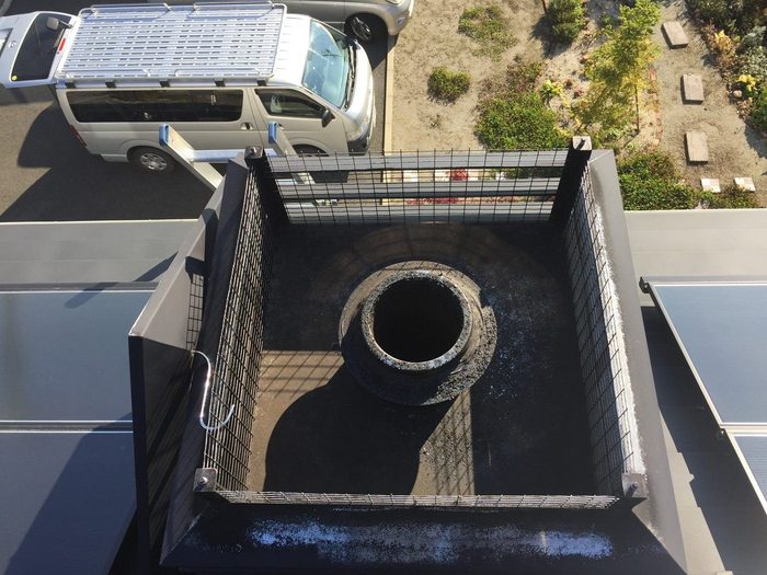 掃除前:ススが溜まった屋根上の煙突トップ