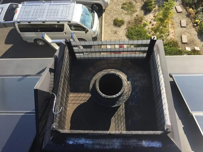 掃除前:ススが溜まった屋根上の煙突トップ