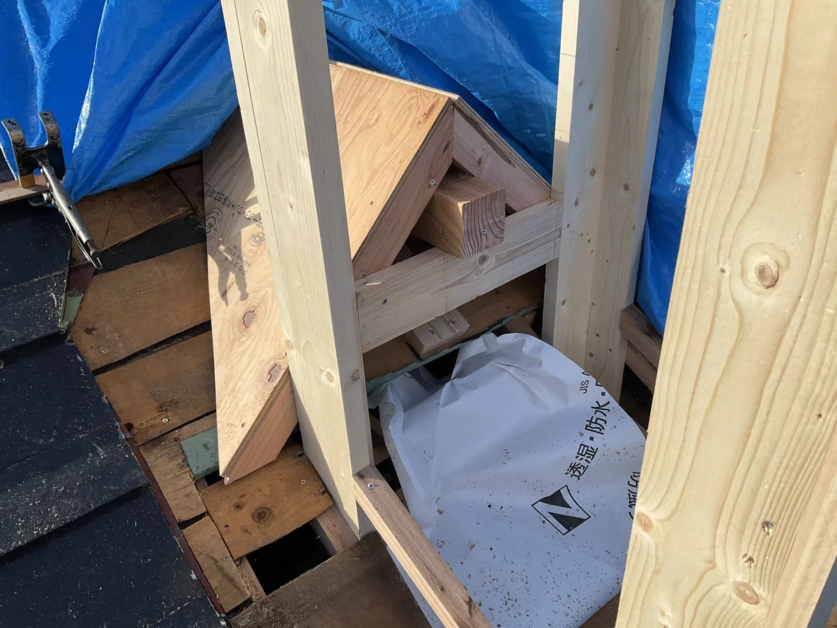 屋根材をはがした上に、新しい角材で四角い枠を組んでいるところ。下に透湿防水シートの袋が見える