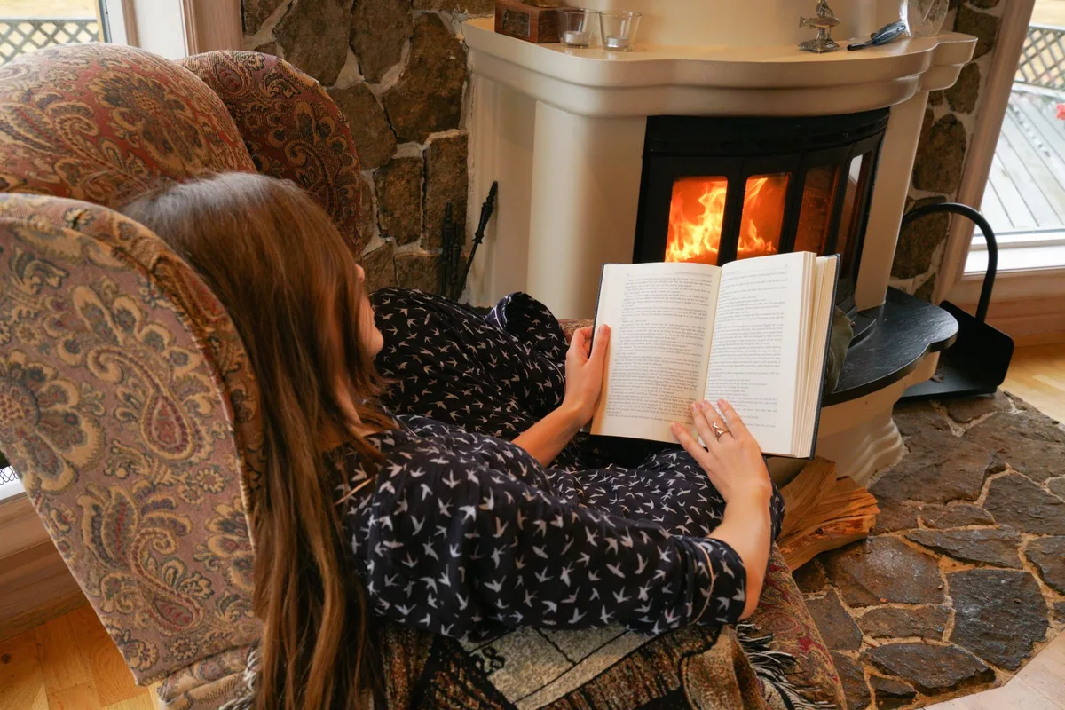 暖炉のそばで本を読む女性
