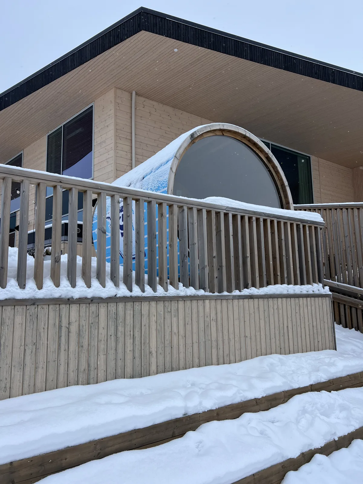 雪の中に建つ木造サウナ小屋と丸い水風呂