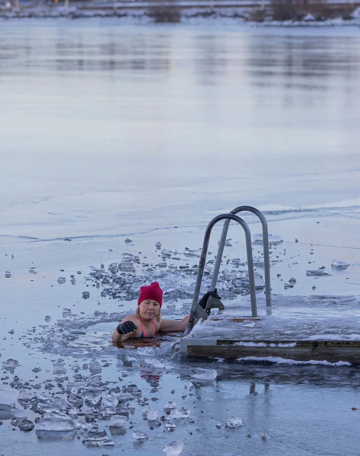 冬の湖の中でラダーにつかまる女性