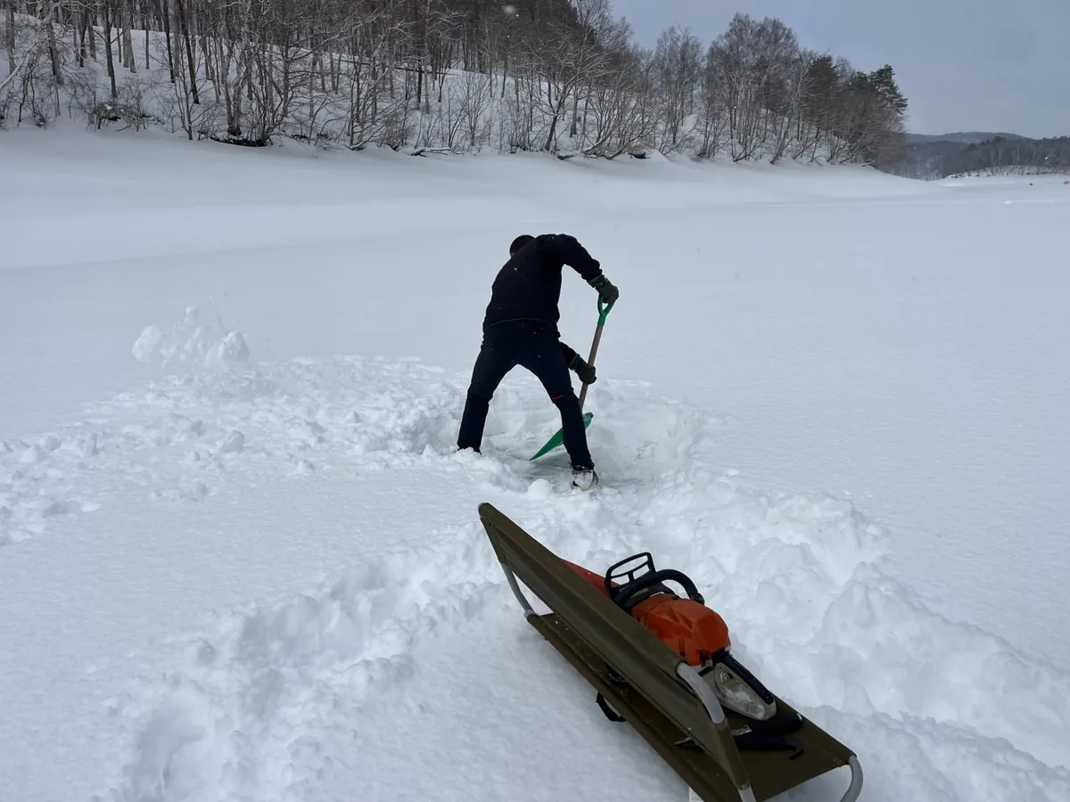 凍った湖の氷を切り抜いて、水風呂の穴をつくる作業。そりに載せたチェンソー