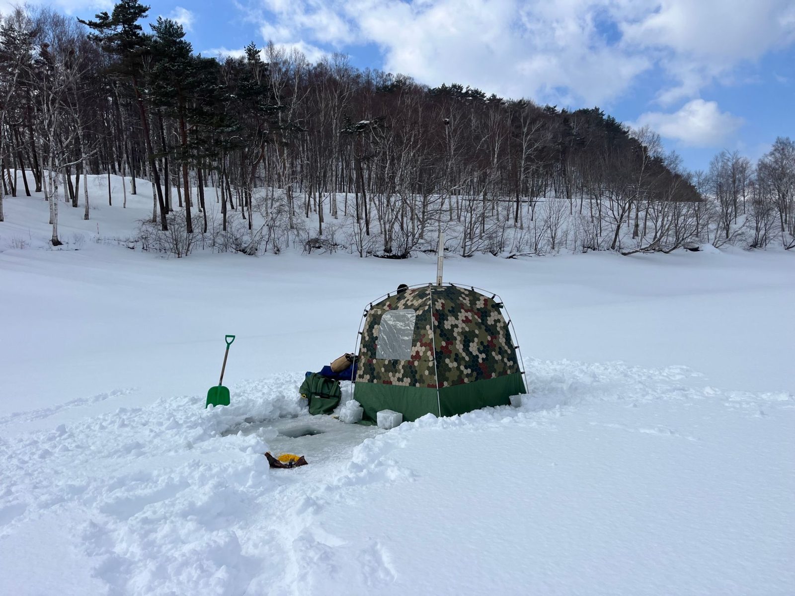 凍った湖の上に張ったテントサウナと、氷を切り抜いてつくった水風呂の穴