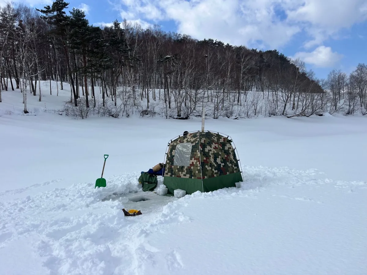 凍った湖の上に張ったテントサウナと、氷を切り抜いてつくった水風呂の穴